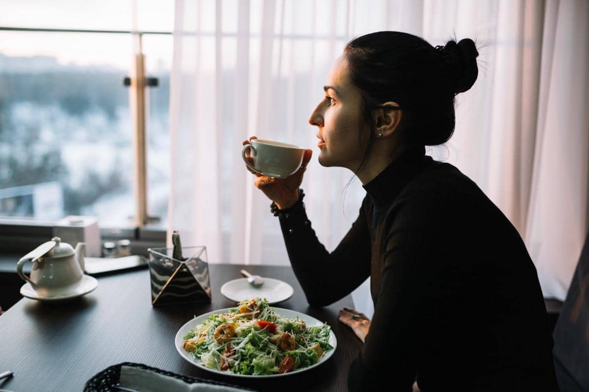 seorang wanita makan saat hujan