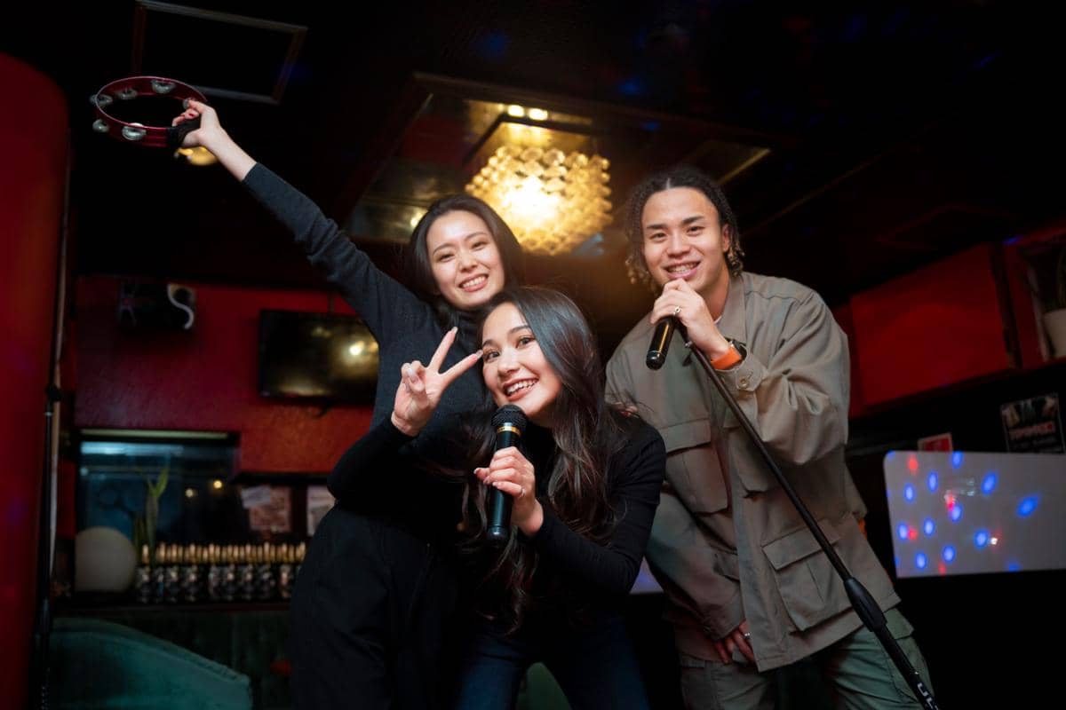 Ilustrasi sekelompok anak muda bernyanyi di ruang karaoke.