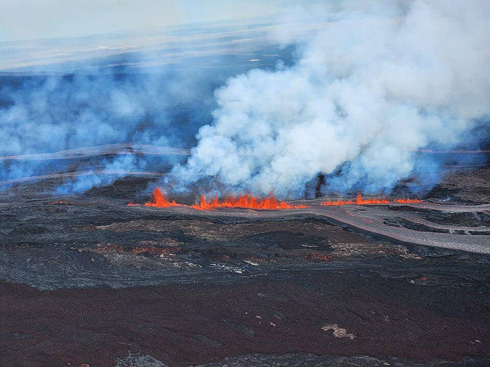 potret lava pijar Mauna Loa memancar dari retakan di permukaan tanah, diiringi kepulan asap putih