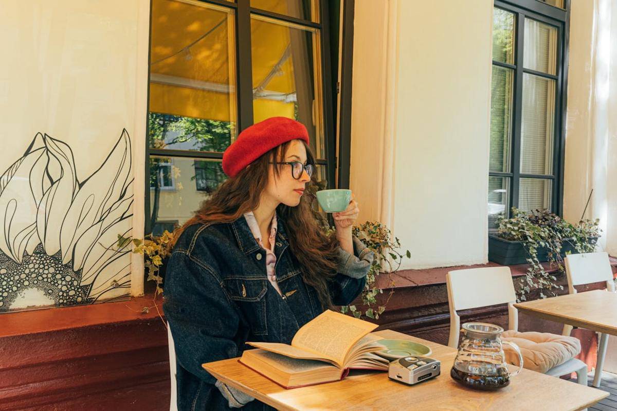 Seorang wanita sedang ngopi di cafe.