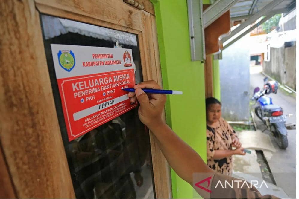 Petugas menempelkan stiker Keluarga Miskin di salah satu rumah Keluarga Penerima Manfaat (KPM) bantuan sosial di Indramayu, Jawa Barat, Senin (26/12/2022). Sebanyak 7.777 rumah Keluarga Penerima Manfaat (KPM) program bantuan sosial dilabeli dengan stiker Keluarga Miskin oleh Dinas Sosial Kabupaten Indramayu sebagai bentuk transparansi penyaluran bansos supaya tepat sasaran. ANTARA FOTO/Dedhez Anggara/rwa.