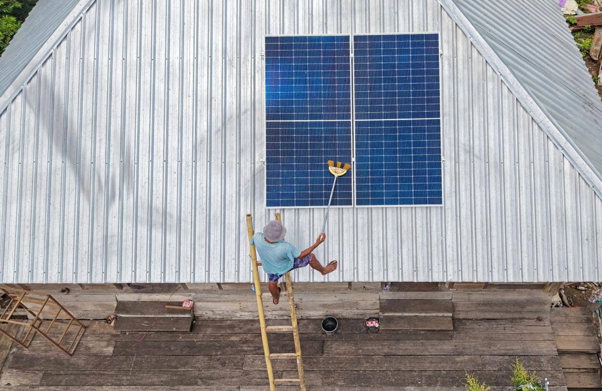 Ilustrasi warga membersihkan panel PLTS atap SuperSUN PLN. (ANTARA FOTO/Ahmad Subaidi)