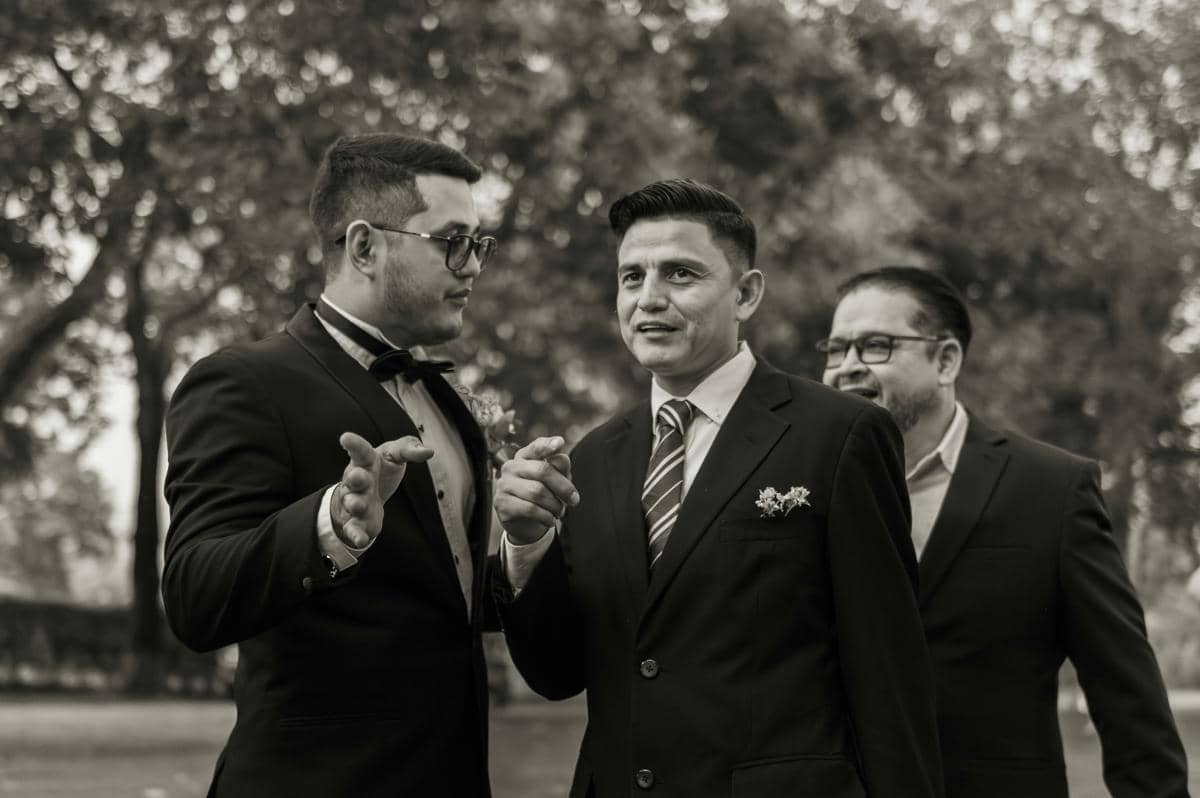 ilustrasi pria berdiri di tengah dua rekan kerja yang sedang berargumen dengan gestur menenangkan