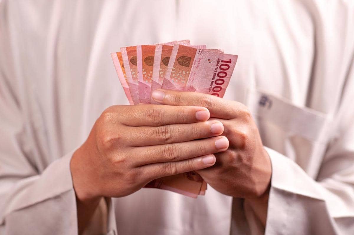 Potret orang memegang uang