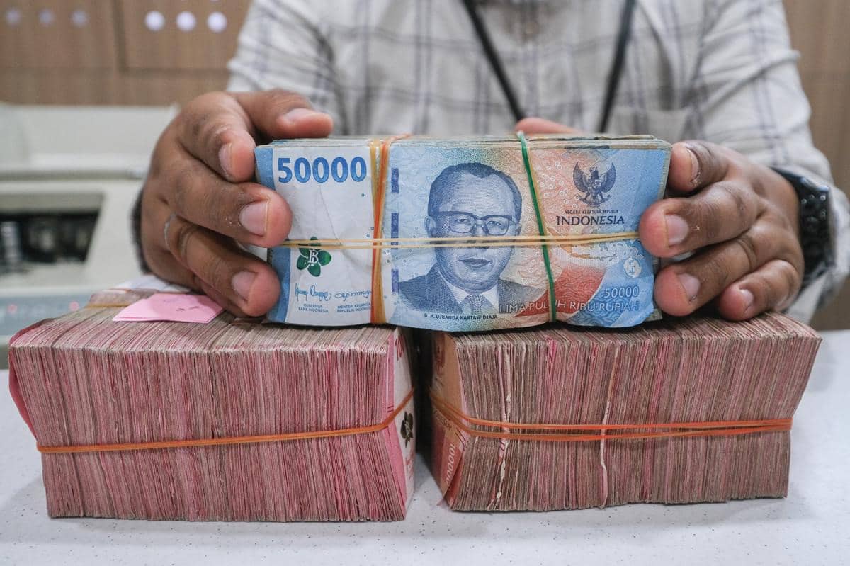 Ilustrasi karyawan menunjukkan uang di Bank Mandiri. (ANTARA FOTO/Andry Denisah)