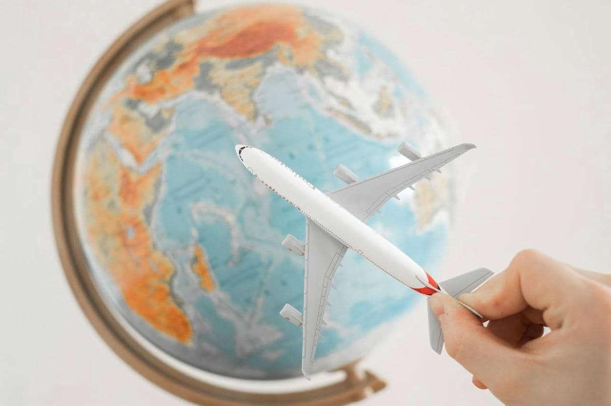 ilustrasi globe dan miniatur pesawat