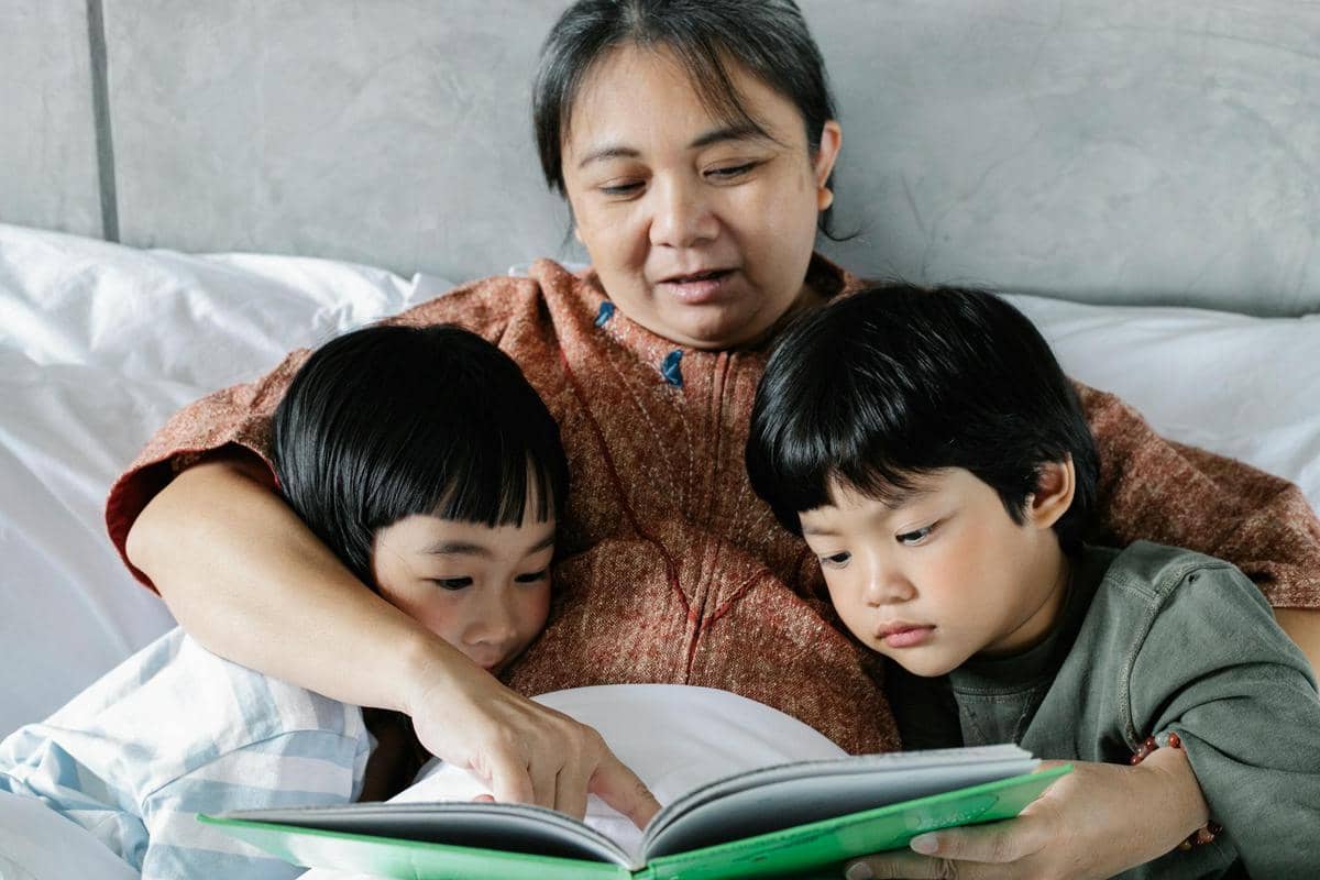Seorang ibu membacakan buku pada anak.