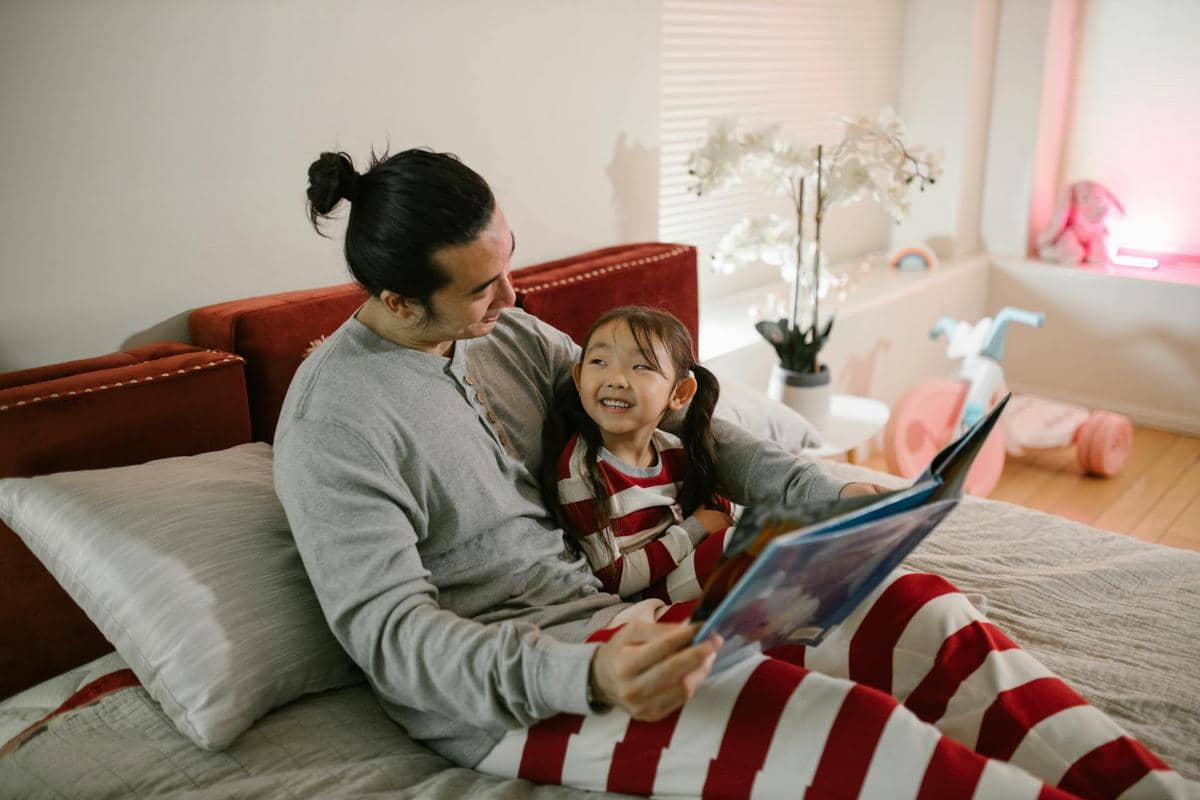 Seorang ayah dan anak melakukan bedtime story.