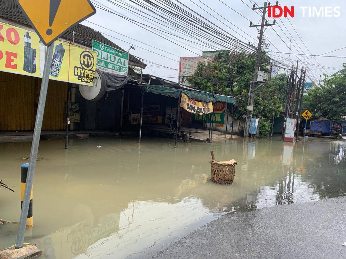 Air masih menggenangi jalan di Kecamatan Marelan, Jumat (28/11/2025) (IDN Times/Doni Hermawan)