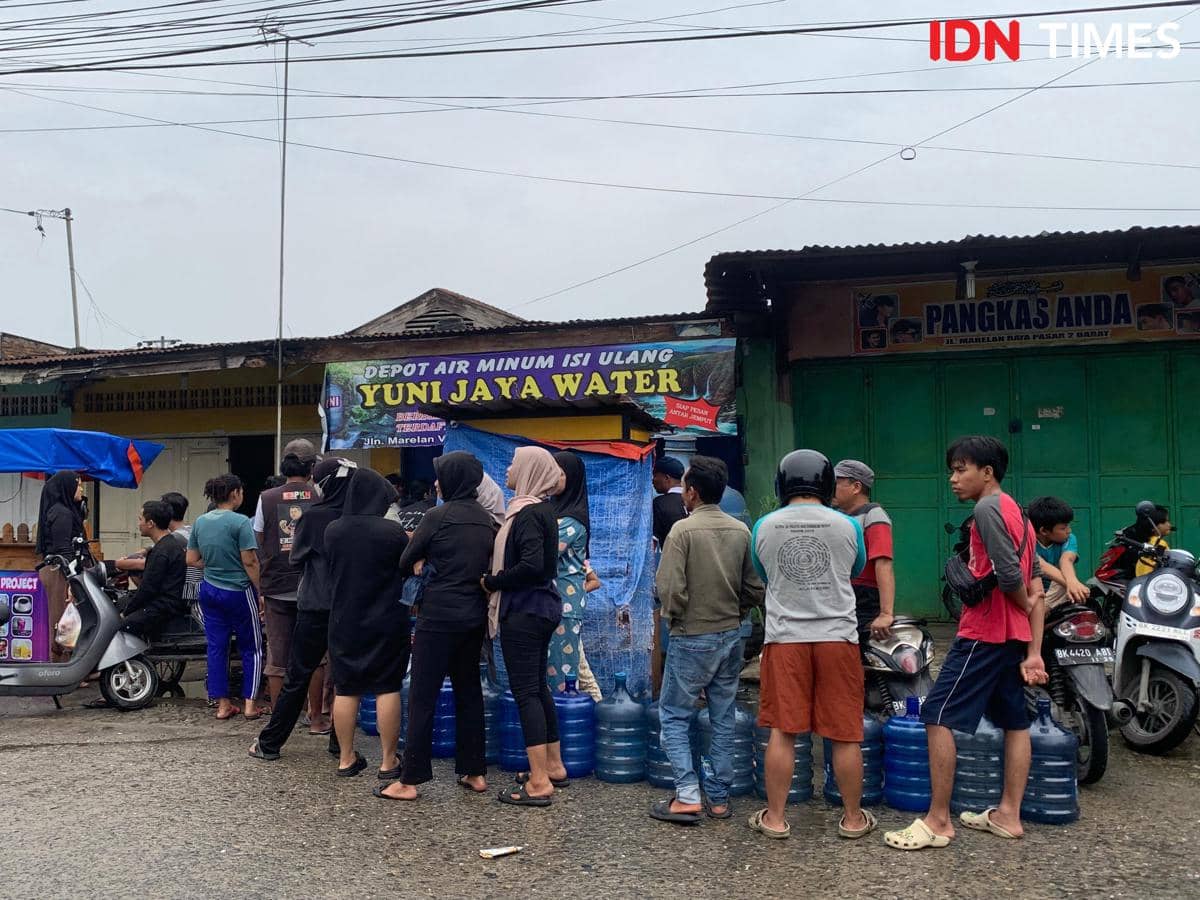 Warga Marelan mengantre di salah satu depot air minum, Jumat (28/11/2025) (IDN Times/Doni Hermawan)