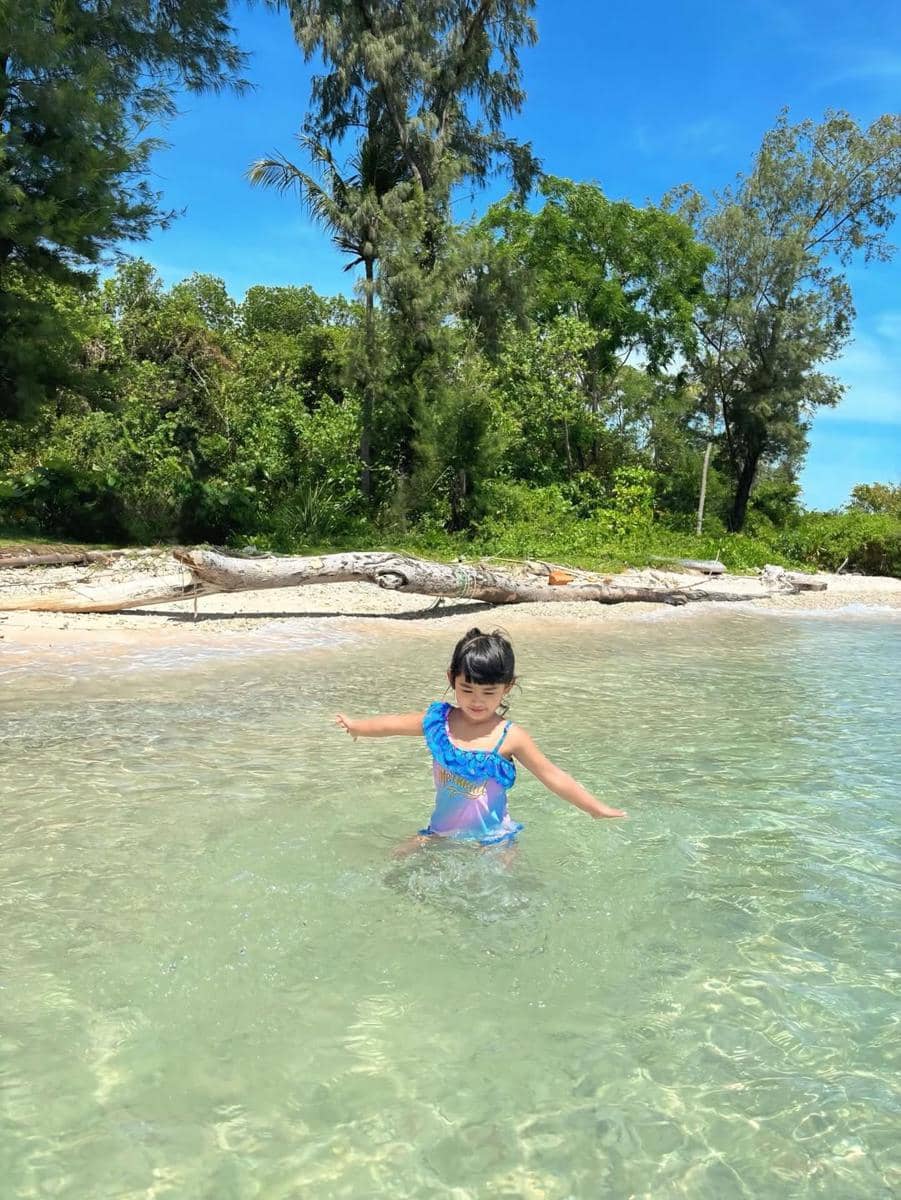 Moana asyik bermain di pantai.