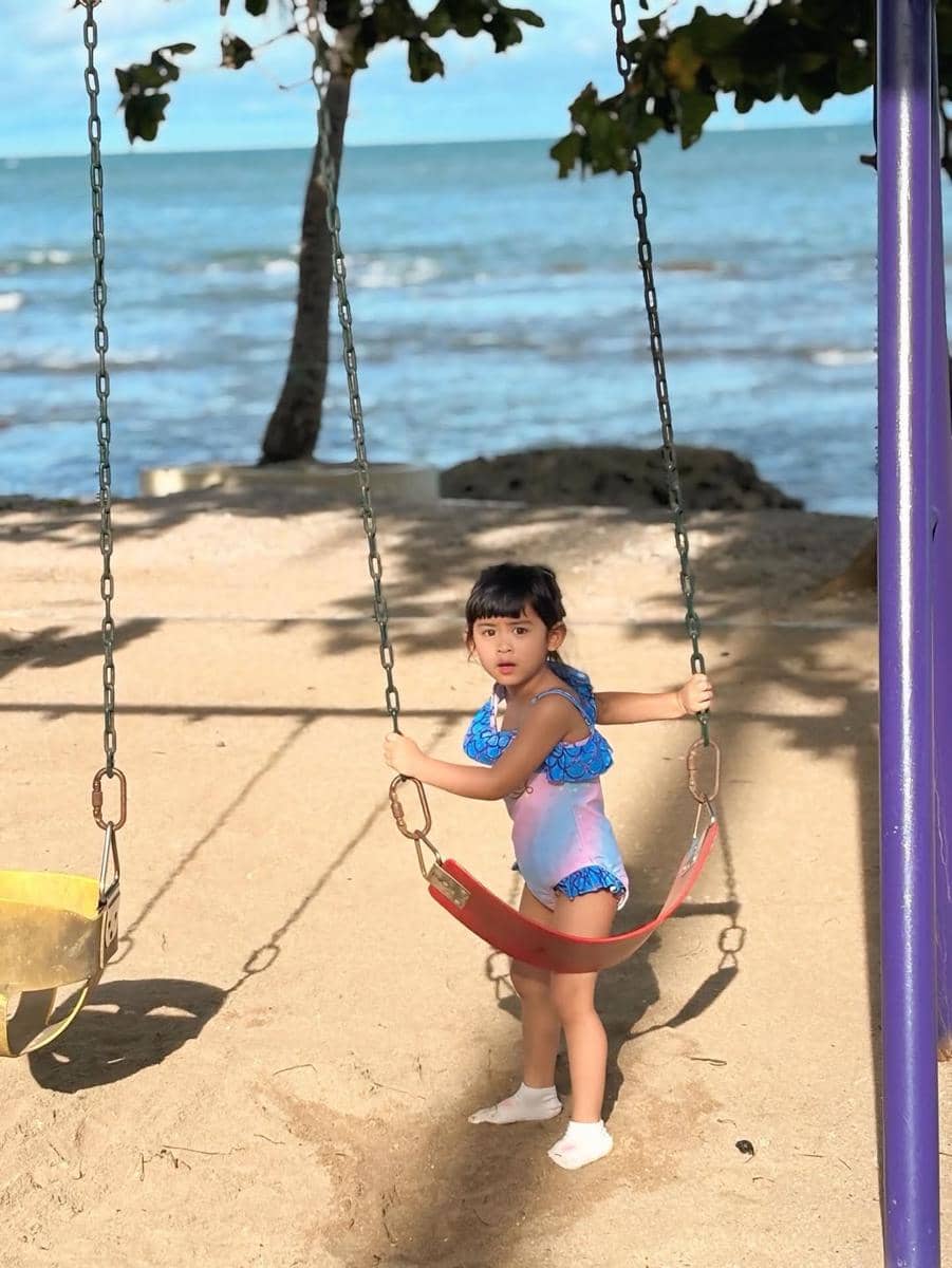 Moana asyik bermain di pantai.