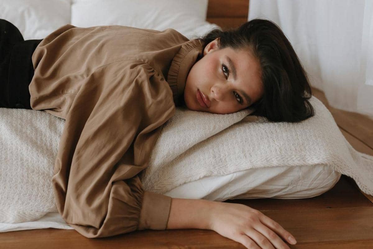 Wanita sedang rebahan lemas.