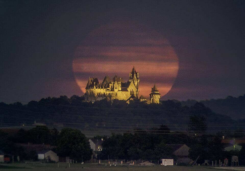 foto tampak menakjubkan karena kastel berada tepat di depan sebuah supermoon
