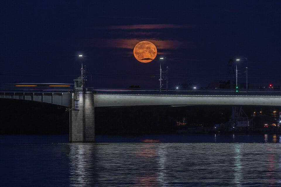 sebuah superbulan yang muncul dengan latar jembatan