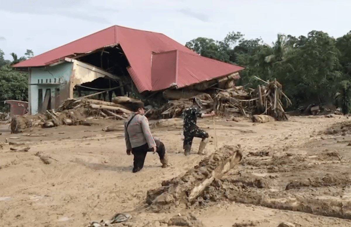 Petugas TNI dan Polri tengah melintas endapan lumpur akibat banjir bandang untuk proses evakuasi di Palembayan, Kabupaten Agam.