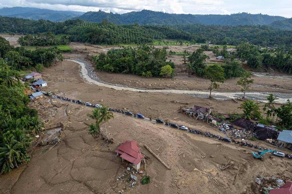 Foto udara antrean kendaraan warga melintasi jalan kawasan permukiman Jorong Kayu Pasak yang rusak akibat banjir bandang di Nagari Salareh Aia, Palembayan, Agam, Sumatera Barat, Minggu (30/11/2025). (ANTARA FOTO/Wahdi Septiawan)