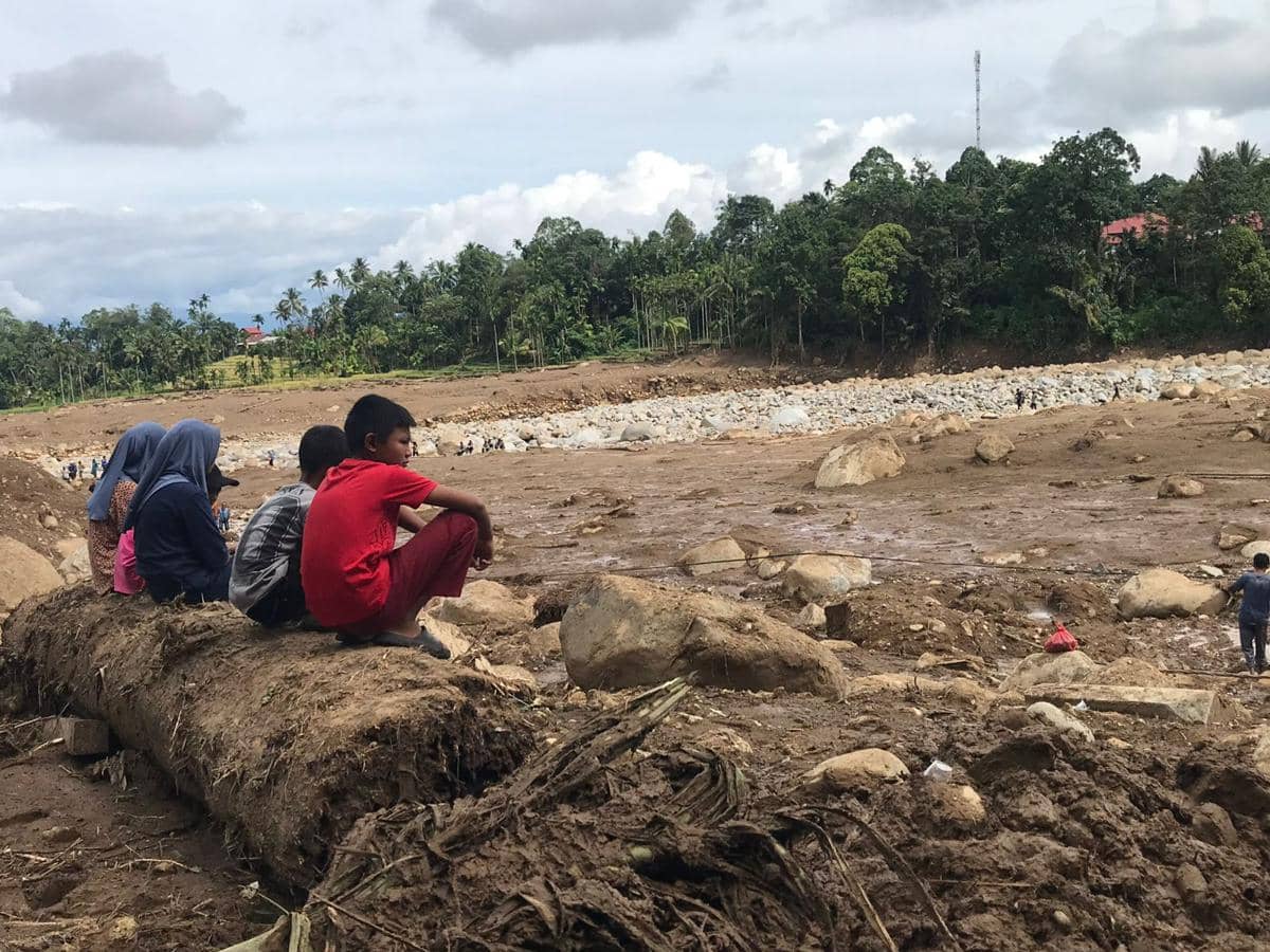 Sekelompok anak sedang memandang ke arah Sungai Batang Nanggang yang meluap saat banjir bandang di Palembayan, Kabupaten Agam, Kamis (27/11/2025).