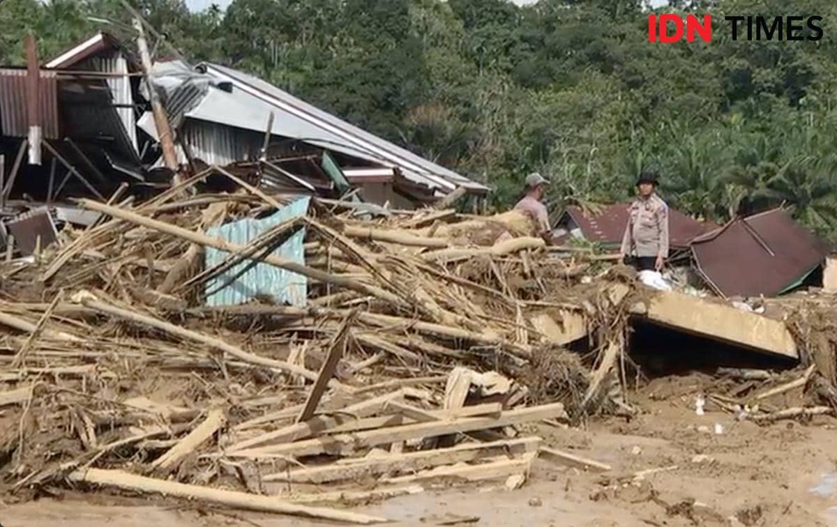 Petugas kepolisian bersama warga sedang melakukan proses evakuasi di bangunan yang runtuh akibat banjir bandang di Palembayan, Kabupaten Agam, Senin (1/12/2025)