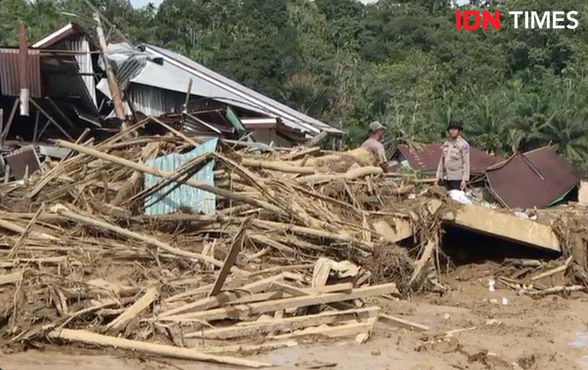 Petugas kepolisian bersama warga sedang melakukan proses evakuasi di bangunan yang runtuh akibat banjir bandang di Palembayan, Kabupaten Agam, Senin (1/12/2025)