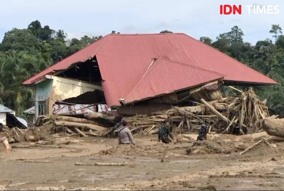 Petugas TNI dan Polri tengah melintas endapan lumpur akibat banjir bandang untuk proses evakuasi di Palembayan, Kabupaten Agam.