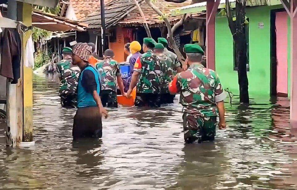 petugas TNI membantu masyarakat yang terdampak banjir
