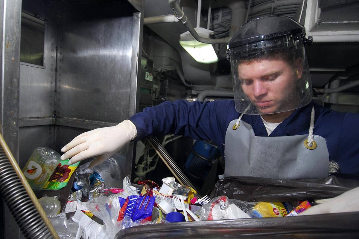 pemeriksaan sampah plastik sebelum diproses dalam mesin penghancur plastik di ruang pemrosesan sampah