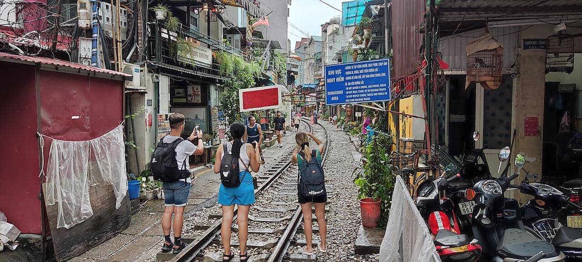 ilustrasi turis bikin konten di train street hanoi 