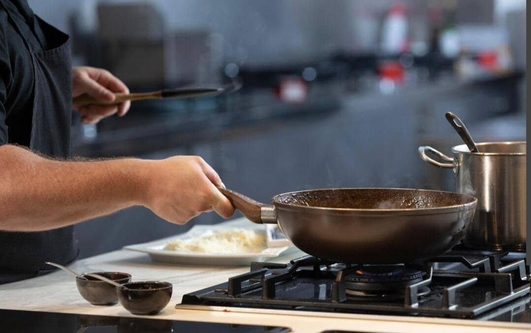 Ilustrasi memasak menggunakan api kecil pada kompor agar makanan matang perlahan dan tidak mudah gosong.