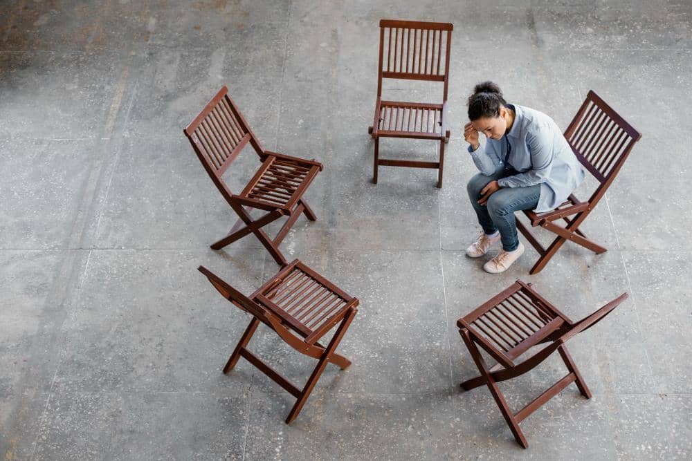 Seorang perempuan duduk sendiri.