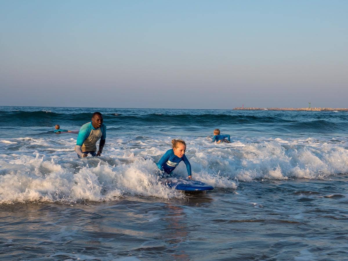 interkasi peselancar lokal dan turis di Pantai Durban, Afrika Selatan