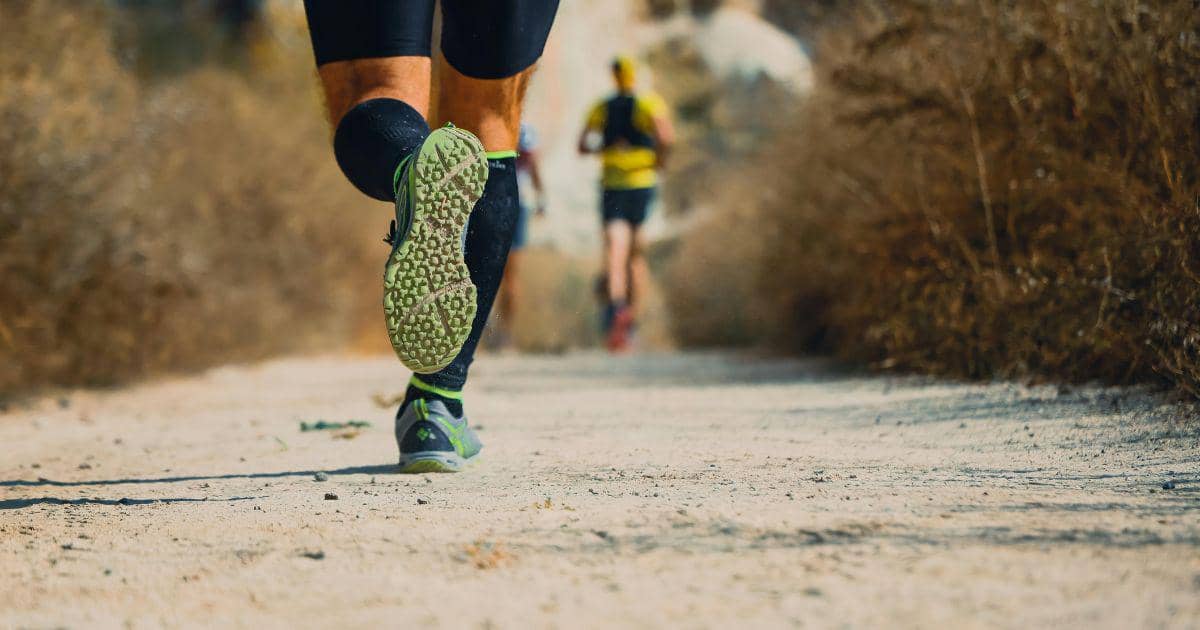 Pria berlari di jalur lomba outdoor