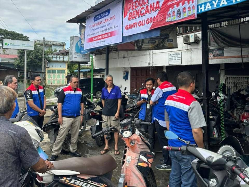 Petugas Pertamina Lubricants melayani ganti oli gratis bagi motor warga terdampak banjir di Medan.jpeg
