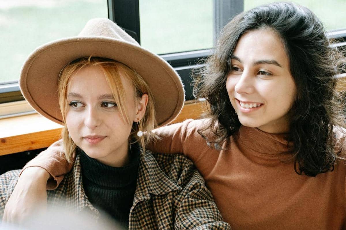 Dua orang wanita sedang duduk bersama.