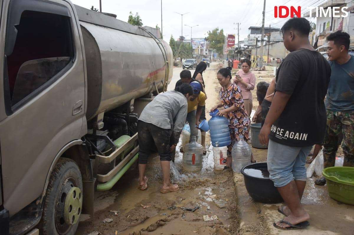 Warga mengambil air bersih yang disuplai dari sebuah mobil tangki di Aceh Tamiang, Sabtu (6/12/2025) (IDN Times/Prayugo Utomo)