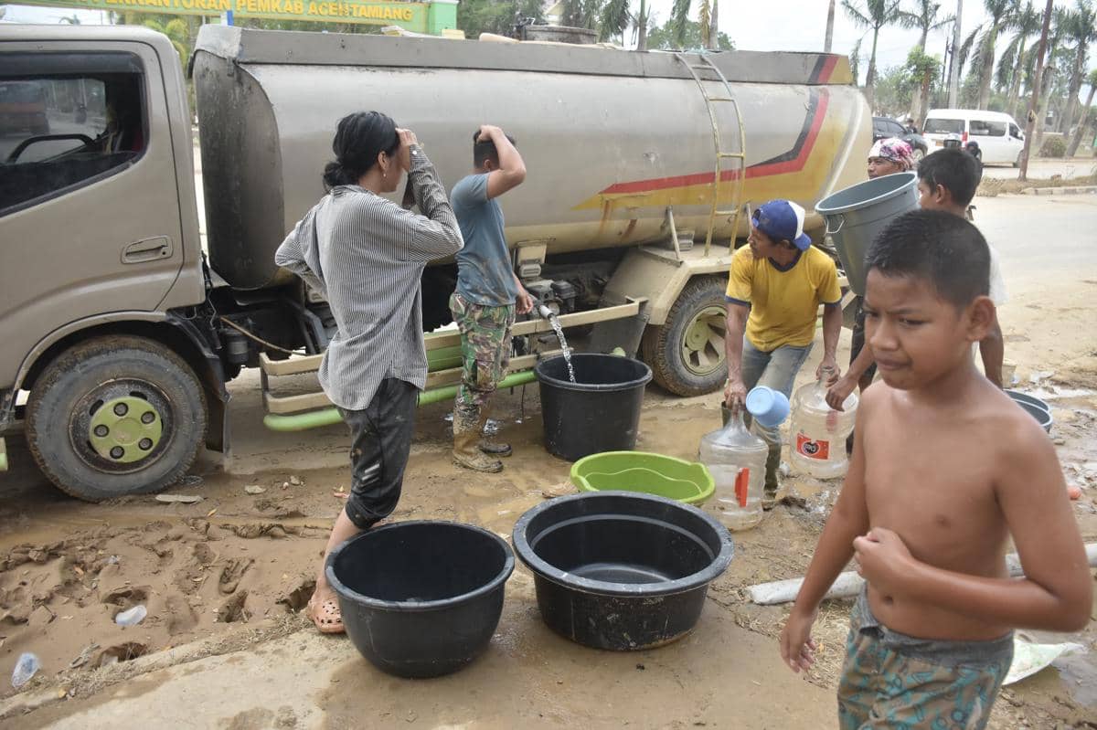 Warga mengambil air bersih yang disuplai dari sebuah mobil tangki di Aceh Tamiang, Sabtu (6/12/2025) (IDN Times/Prayugo Utomo)