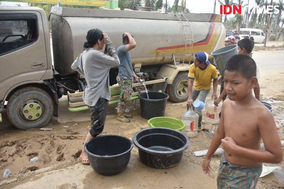 Warga mengambil air bersih yang disuplai dari sebuah mobil tangki di Aceh Tamiang, Sabtu (6/12/2025) (IDN Times/Prayugo Utomo)