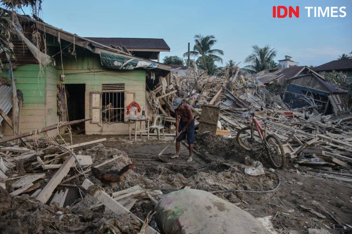Warga Tamiang membersihkan rumahnya dari puing-puing sisa banjir bandang, Jumat (5/12/2025) (IDN Times/Prayugo Utomo)