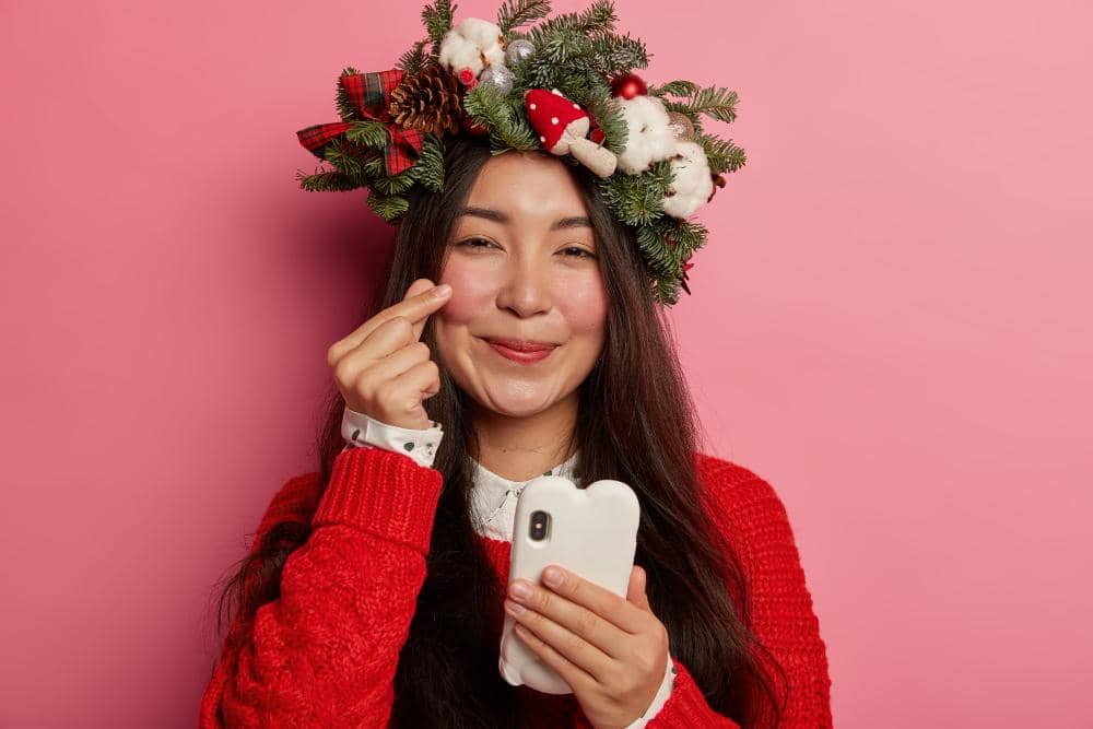 Adorable young lady smiles pleasantly wearing festive wreath on head