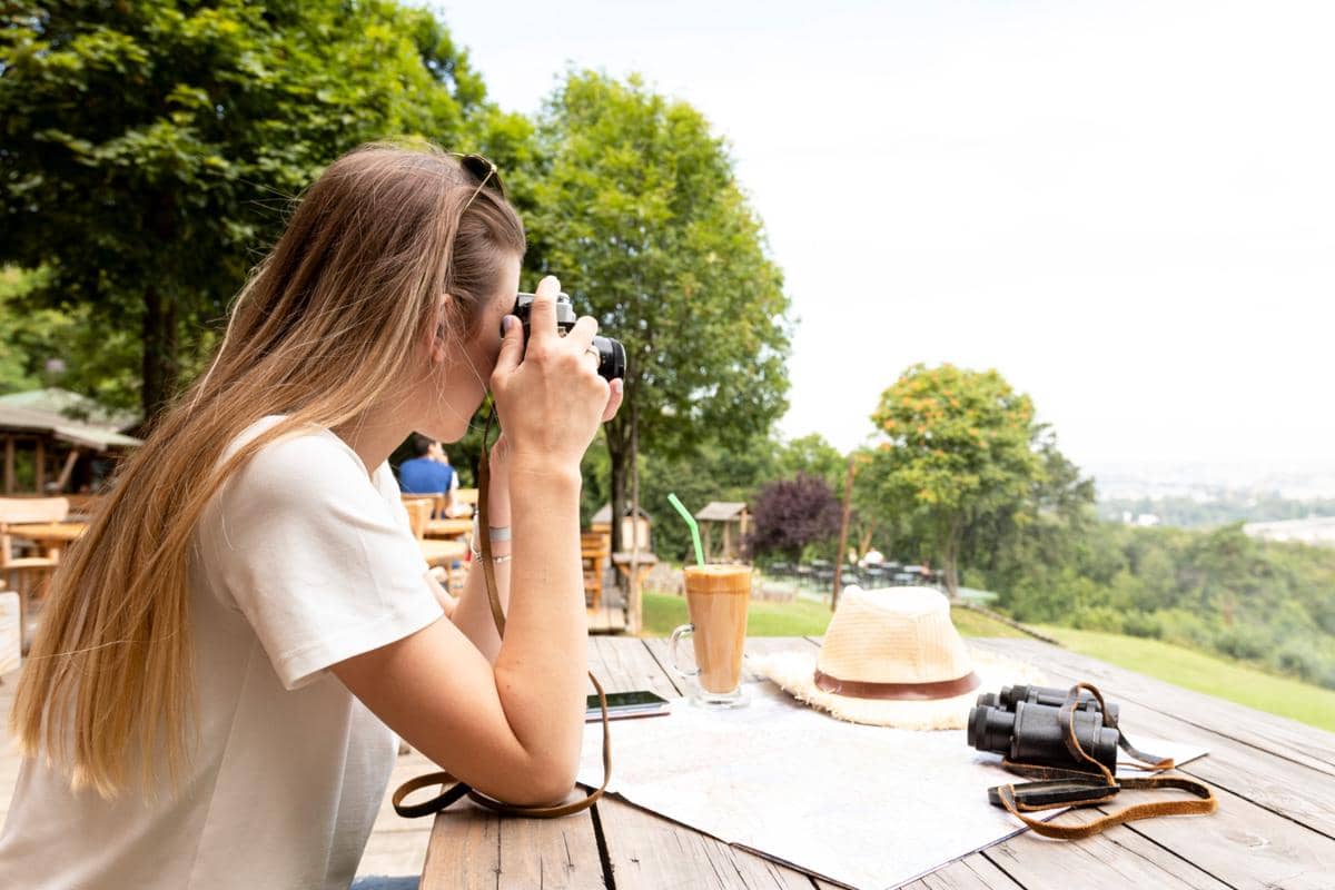 Ilustrasi wanita memfoto pemandangan dan ngopi