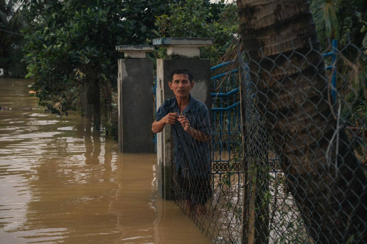seseorang yang berdiri di tengah banjir