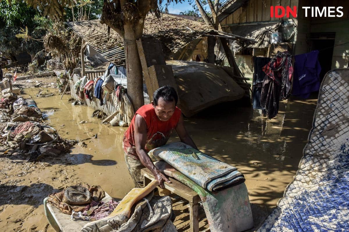 Penyintas banjir membersihkan barang-barang yang tersisa dari dalam rumah, Minggu (7/12/2025). Banjir menerjang Kabupaten Aceh Tamiang, Aceh sejak Rabu (25/11/2025). (IDN Times/Prayugo Utomo)