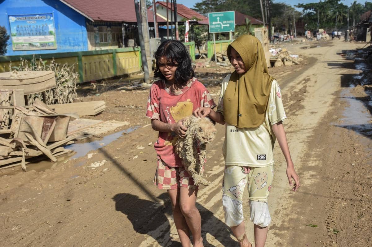 Dua anak penyintas banjir membawa kucing peliharaan, Minggu (7/12/2025). Banjir menerjang Kabupaten Aceh Tamiang, Aceh sejak Rabu (25/11/2025). (IDN Times/Prayugo Utomo)