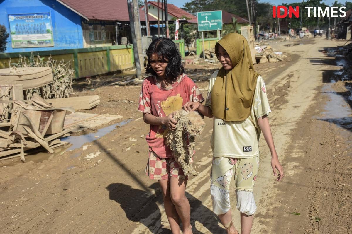 Dua anak penyintas banjir membawa kucing peliharaan, Minggu (7/12/2025).  Banjir menerjang Kabupaten Aceh Tamiang, Aceh sejak Rabu (25/11/2025). (IDN Times/Prayugo Utomo)