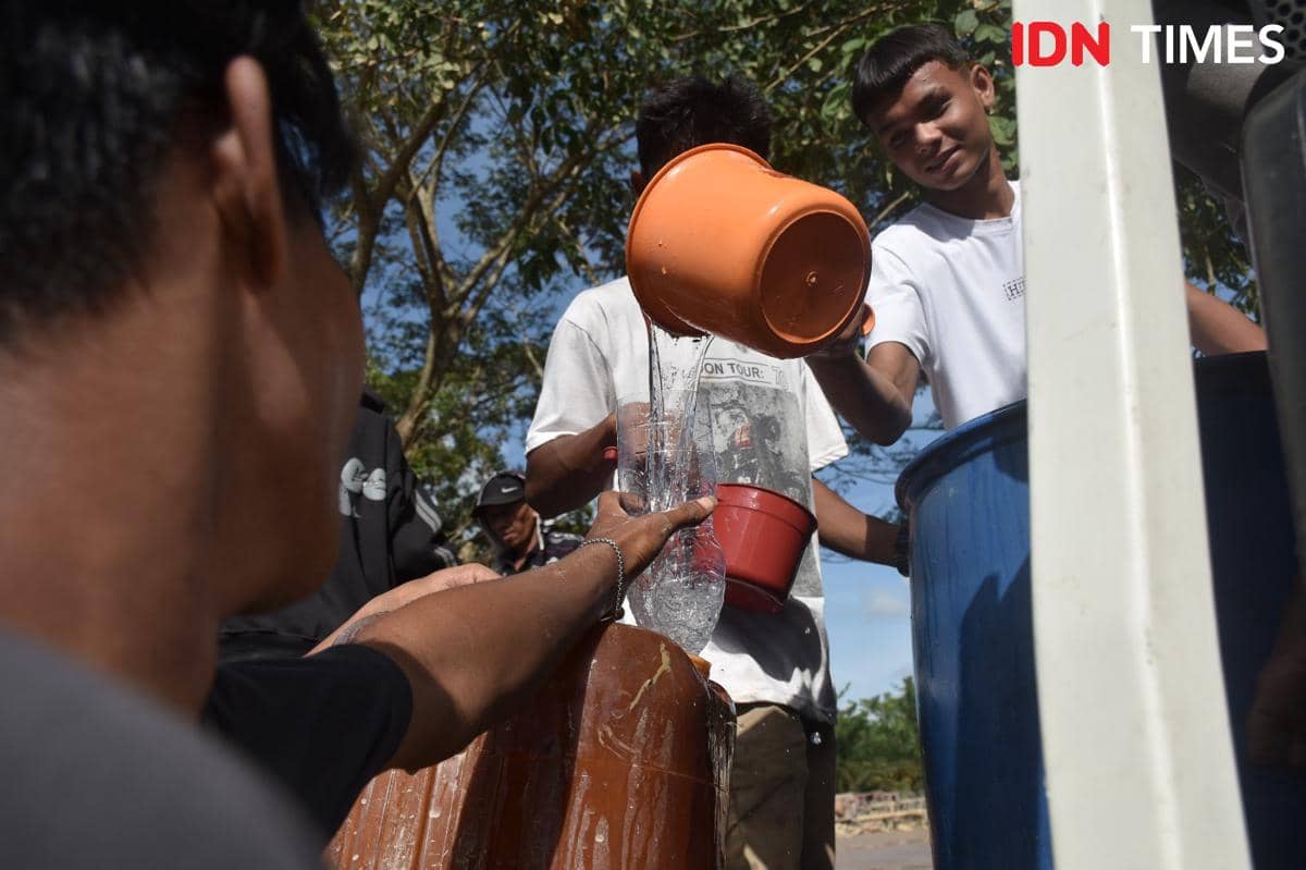 Warga Aceh Tamiang saling membantu memberi air bersih, Minggu (7/12/2025) (IDN Times/Prayugo Utomo)