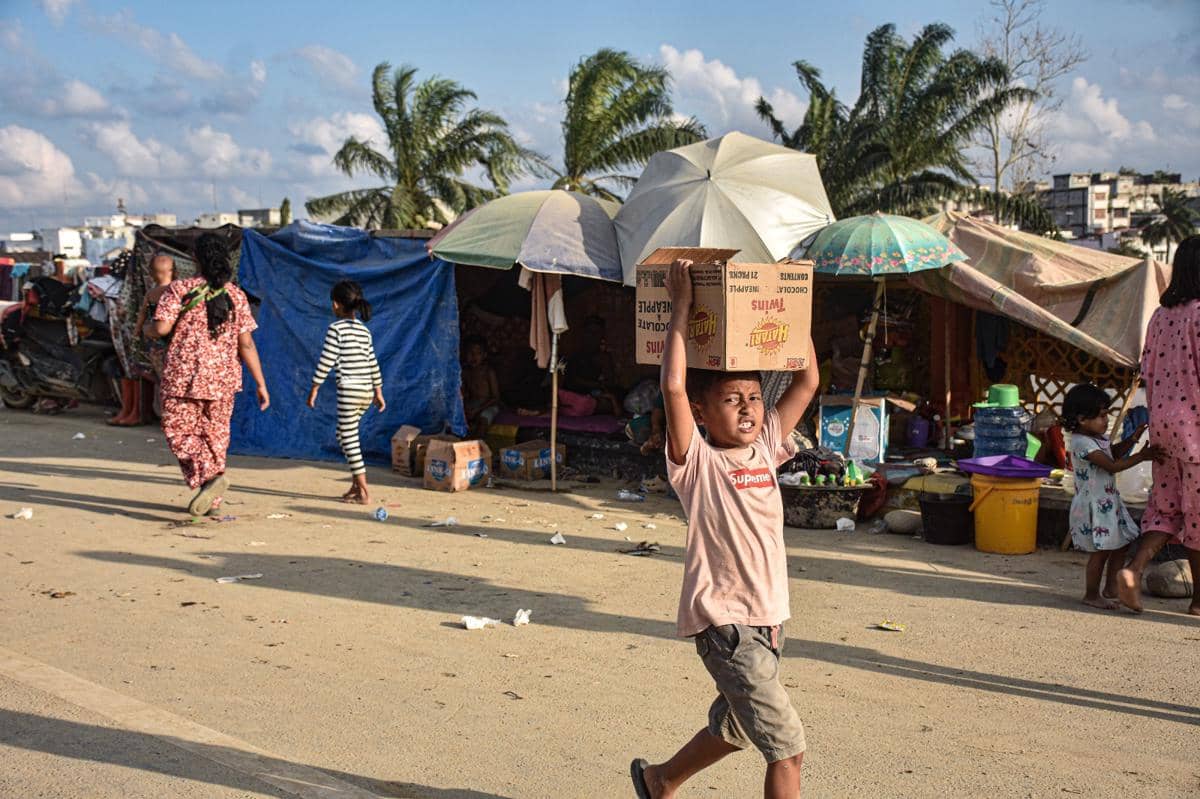 Seorang anak penyintas banjir membawa logistik yang dibagikan relawan di Kecamatan Kuala Simpang, Jumat (5/12/2025). (IDN Times/Prayugo Utomo)