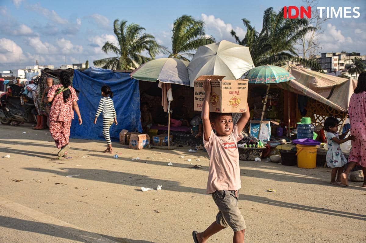 Seorang anak penyintas banjir membawa logistik yang dibagikan relawan di Kecamatan Kuala Simpang, Jumat (5/12/2025). (IDN Times/Prayugo Utomo)