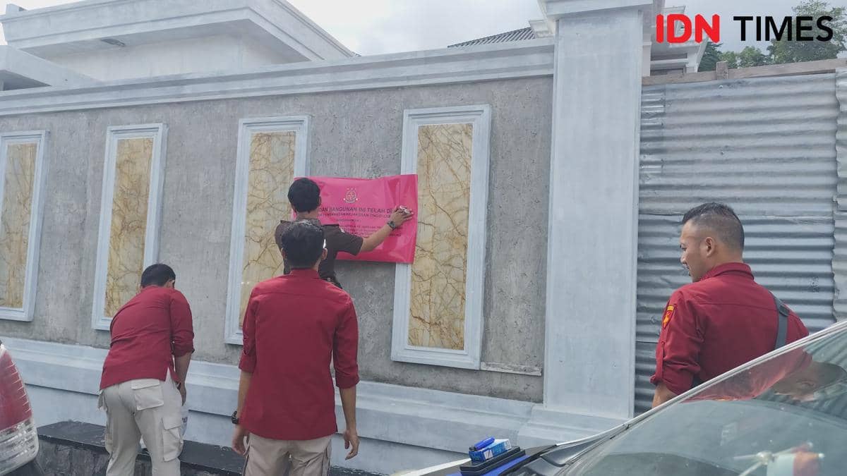 Pemasangan stiker penyitaan rumah oleh Kejati Lampung di rumah eks Bupati Pesawaran, Dendi Romadhona.