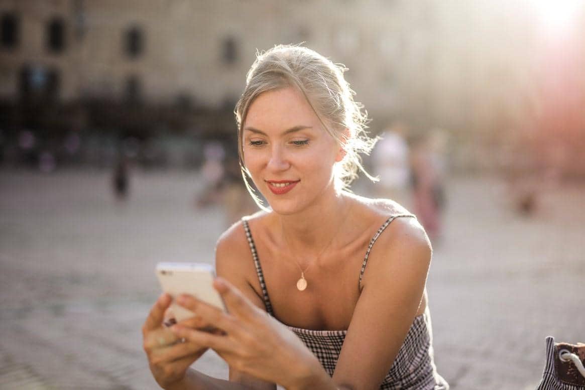 Seorang wanita sedang memainkan handphonenya.