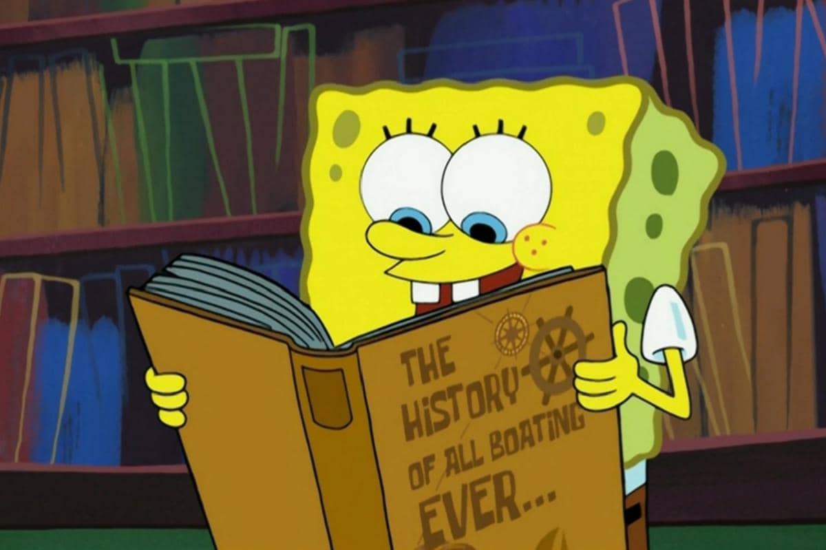 SpongeBob membaca salah satu buku dari rak perpustakaan rumahnya